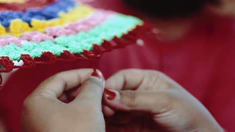 Close-up-of-the-hands-of-an-Indian-girl-knitting-the-ornaments-of-a-traditional-umbrella-in-India,-traditional-clothing-concept