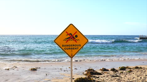 Crash-zoom-into-dangerous-current-sign-at-Bondi-Beach,-Sydney-Australia