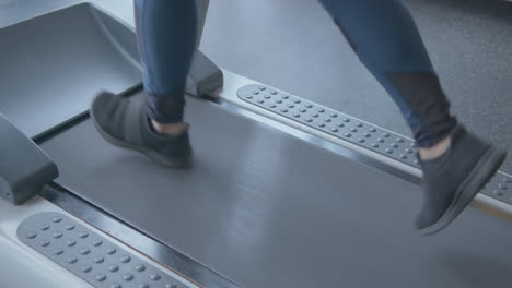 Close-Up-Slow-Motion-of-a-Woman's-Legs-Jogging-on-a-Treadmill