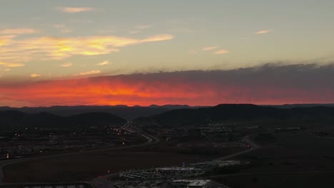 Aufnahme-Einer-Luftaufnahme-über-Rapid-City,-South-Dakota-Während-Eines-Warmen-Orange-roten-Sonnenuntergangs