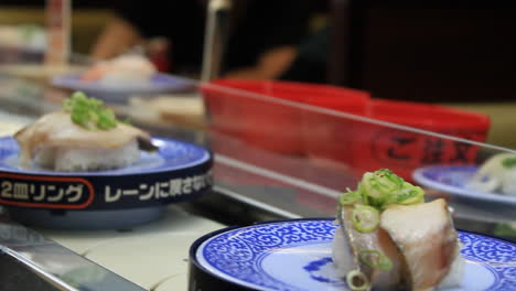 Mittlere-Aufnahme-Eines-Fließband-Sushi--Oder-Rotations-Sushi--Oder-Sushi-Zug-Restaurants-In-Osaka,-Japan