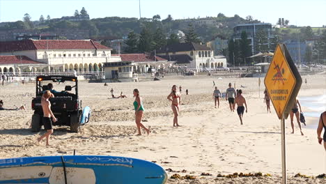 A-Bondi-Lifeguard-buggy-drives-along-the-beach-on-a-summer-morning-at-Bondi-Beach,-Sydney-Australia