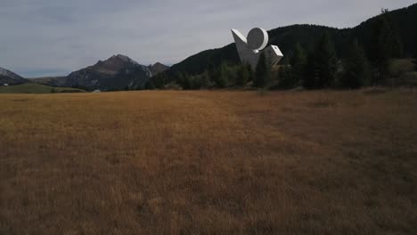 Aerial-forward-over-Plateau-des-Glieres-with-national-resistance-monument,-Haute-Savoie-in-France