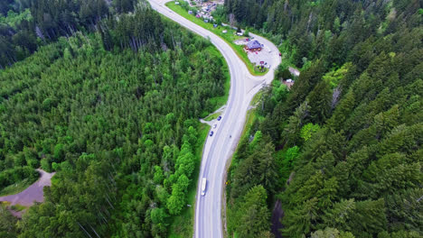 Vehicles-Driving-Along-Curved-Countryside-Road-Through-Forest-in-Port-Alberni-Region,-British-Columbia-Canada,-Aerial-View
