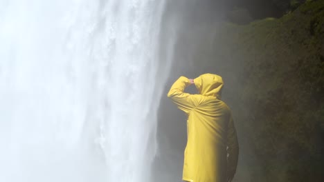 Woman-Wearing-Yellow-Jacket-Skógafoss-in-Iceland,-4K