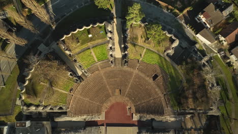 People-walking-in-the-roman-theater-Augusta-Raurica-top-down-drone-lifting-shot