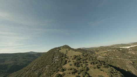 Aerial-ascends-over-mountain-top-green-meadow-in-Spanish-countryside