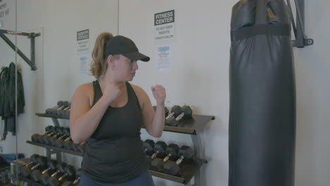 Wide-Slow-Motion-of-a-Young-Woman-Punching-a-Punching-Bag