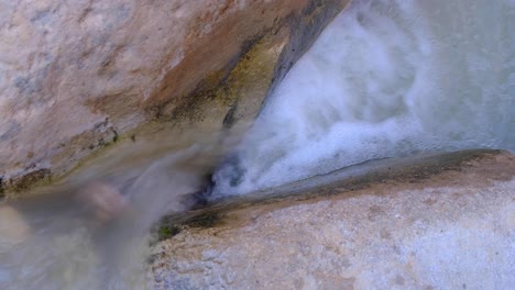 Ein-Kleiner-Bach-Mit-Schnell-Fließendem-Wasserfall-Und-Wildwasser-Kaskadiert-über-Natürlich-Geformte,-Glatte,-Vom-Wasser-Tief-In-Der-Schlucht-Geformte-Wasser
