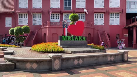 Iconic-historic-Dutch-Square-against-maroon-coloured-structures-in-the-colonial-style-in-Malacca,-Malaysia