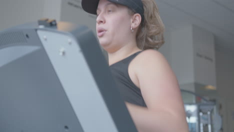 Close-Up-Tilt-Up-of-a-Young-Jogging-on-a-Treadmill