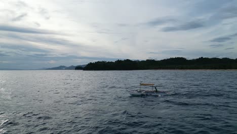 Drone-Side-Shot-of-Philippine-Bangka-Boat-sailing-through-idyllic-Sea-during-Late-Afternoon-in-Catanduanes,-Philippines