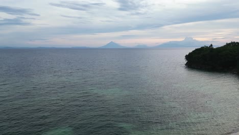 Luftaufnahme,-Drohnenaufnahme-Eines-Atemberaubenden-Strandes-Mit-Der-Silhouette-Des-Mayon-Vulkans-Im-Hintergrund-Während-Der-Abenddämmerung,-Catanduanes,-Philippinen