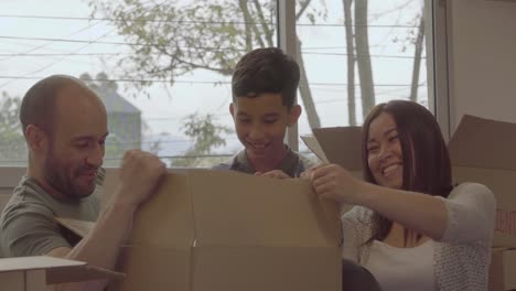 Parents-and-a-young-son-unpack-a-gift-and-unwrap-other-packages