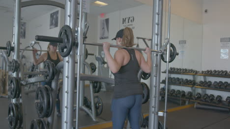 Wide-Pan-Right-of-a-Woman-Doing-Barbell-Squats-in-Slow-Motion