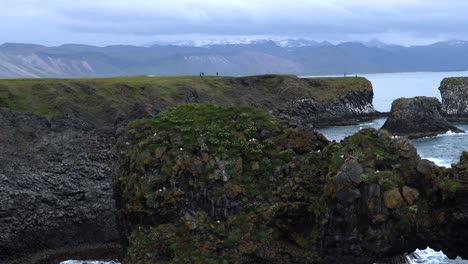 Rock-reaching-out-of-Water-at-Arnarstapi-on-Peninsula-Snæfellsnes-in-Iceland,-4K