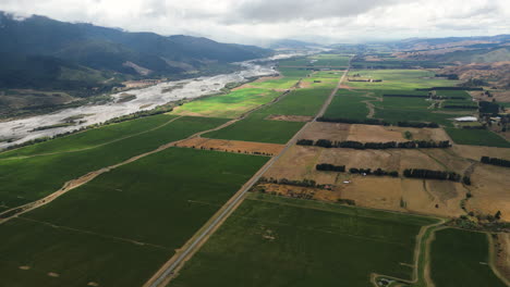 Endless-green-wine-fields-of-New-Zealand-new-powerful-river,-aerial-view