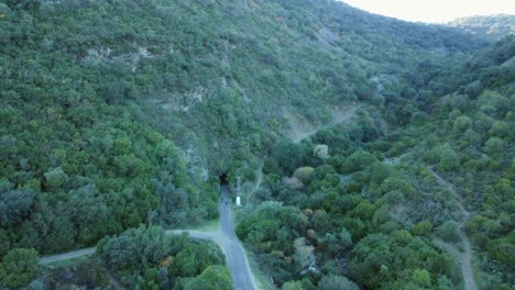 Aerial-view-as-two-cyclists-on-rail-trail-enter-old-railway-tunnel