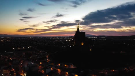 Aerial-drone-shot-of-Monteagudo-Christ-statue-and-castle-at-night-in-Murcia,-Spain