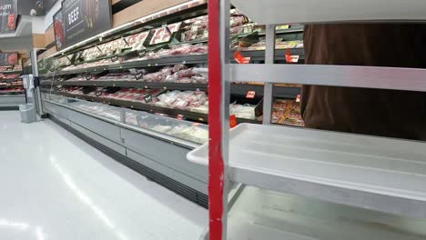 Employee-restocking-the-meat-displays-in-an-American-grocery-store