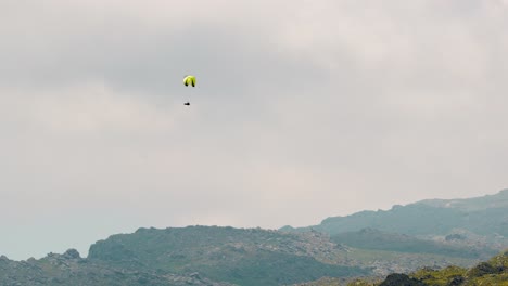 Paragliding-High-Above-a-Mountain-Range-on-a-cloudy-day-in-Merlo,-San-Luis,-Argentina