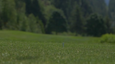 Golfer-swing-driving-ball-with-wood-club-onto-the-course-in-slow-motion-close-up