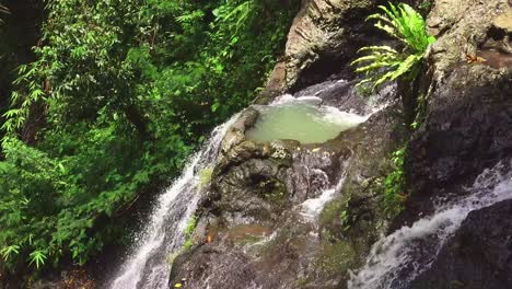 Gembleng-cascading-waterfall-flows-down-amongst-lush-green-tropical-rocks