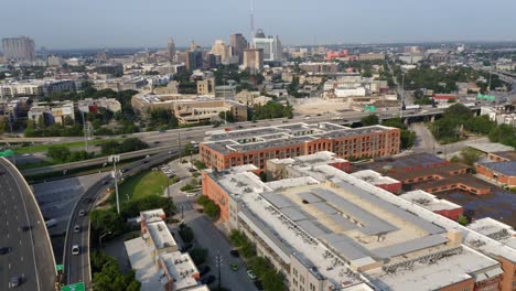 San-Antonio-Pearl-District-aerial-view-of-downtown-city-skyline-in-the-morning,-pan-right-over-freeway-commuters-and-apartment-complex-near-riverwalk-in-4k