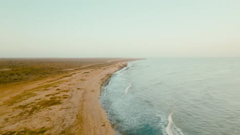 Toma-Aérea-De-La-Playa-Desierta-Y-El-Océano-Al-Atardecer,-Colombia,-La-Guajira