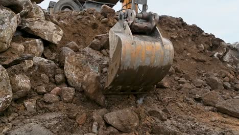Close-up-of-an-excavator-bucket-working,-heavy-equipment-excavating-soil-and-rocks,-no-people
