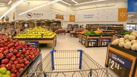 Pushing-an-emptying-grocery-cart-through-the-produce-section-towards-the-bakery-and-the-exit-doors