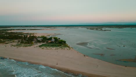 Aerial-shot-of-the-beach-and-the-river-on-sunset,-Colombia,-la-guajira