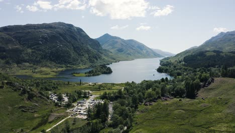 Aerial-view-over-the-town-of-Glenfinnan-in-Scotland's-countryside-featuring-Loch-Shiel-in-the-backdrop