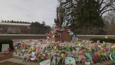 Spartan-Statue-on-the-campus-of-Michigan-State-University-with-flowers-after-the-mass-shooting-in-February-of-2023-with-gimbal-video-walking-sideways