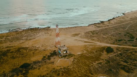 Aerial-view-of-a-lighthouse-in-the-desert-and-the-sea,-the-northest-point-in-Colombia-and-Southamerica,-Puntagallinas