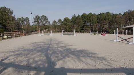 Fenced-area-where-horses-are-trained,-with-obstacles
