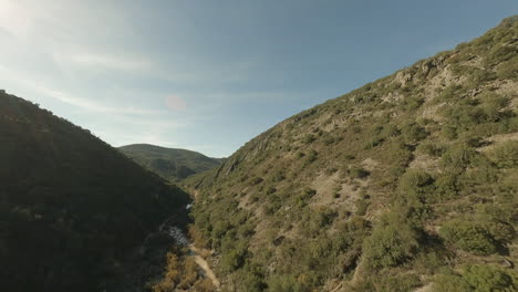 FPV-aerial-up-rugged,-rocky,-arid-river-valley-near-Seville,-Spain