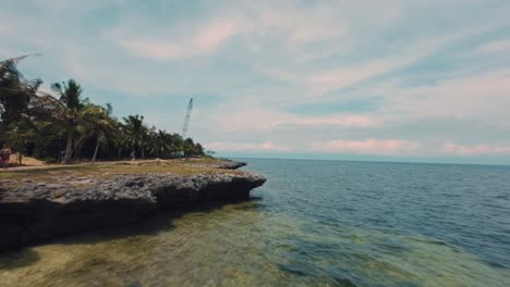 Fpv-drone-flyover-water-surface-towards-rocky-shoreline-in-Bohol---Philippines