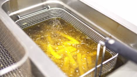 Slow-rotating-shot-of-golden-colored-fries-cooking-in-a-fryer