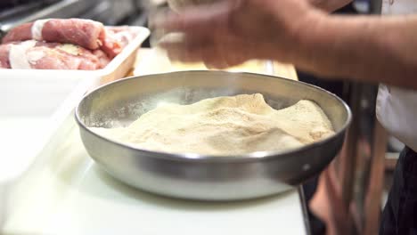 Primer-Plano-De-Un-Chef-Experimentado-Empanado-Bistecs-Y-Sumergiéndolos-En-Huevo-Para-Freír