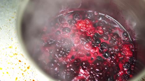 Close-up-shot-of-berries-boiling-in-a-metal-pot-making-compote