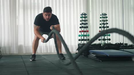 Young-Man-Using-Battle-Ropes-For-Whipping-Exercise-in-a-Gym