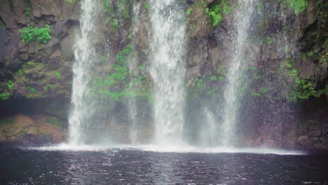 Slow-motion-shot-of-waterfall-crashing-into-natural-lake-in-Mauritius---medium-shot