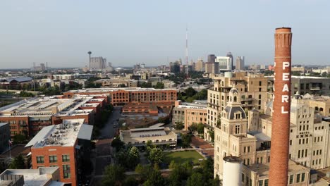 San-Antonio-Pearl-District-aerial-view-pan-left-past-brick-tower,-shops-and-restaurants-with-drone-in-4k