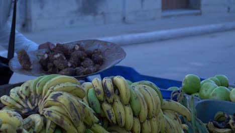 Cuban-Peddler-selling-cocoyams-in-the-street,-focus-back-to-front-slow-motion