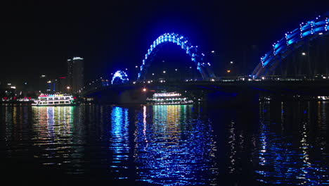Nachtansicht-Der-Drachenbrücke-In-Der-Vietnamesischen-Stadt-Da-Nang,-Die-über-Dem-Han-Fluss-Gebaut-Wurde,-Und-Kreuzfahrtschiffen-Darüber
