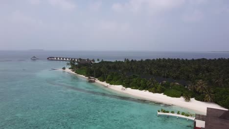 Drone-view-of-the-island-and-water-villas-on-a-luxury-Maldivian-resort