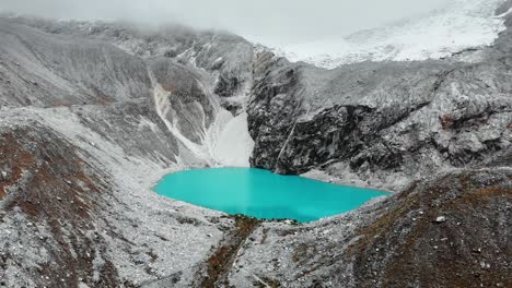 Bright-blue-Lagoon-69,-Aerial,-in-the-midst-of-the-snowy-mountains-and-glaciers,-Peru,-South-America