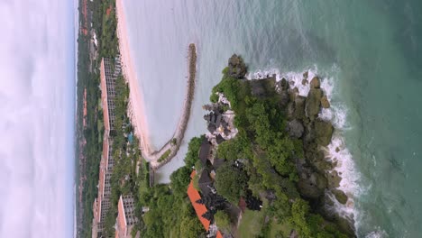 Aerial-drone-panning-vertical-shot-of-a-hinduism-temple-above-a-cliff-in-Bali