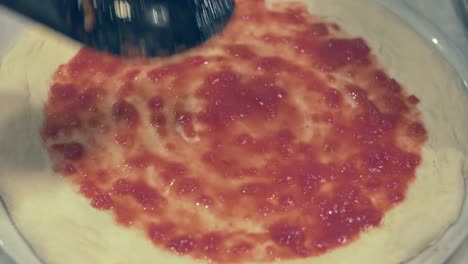 Chef-Italiano-Esparciendo-En-Círculos-Salsa-De-Tomate-Fresco-Sobre-La-Masa-De-Pizza